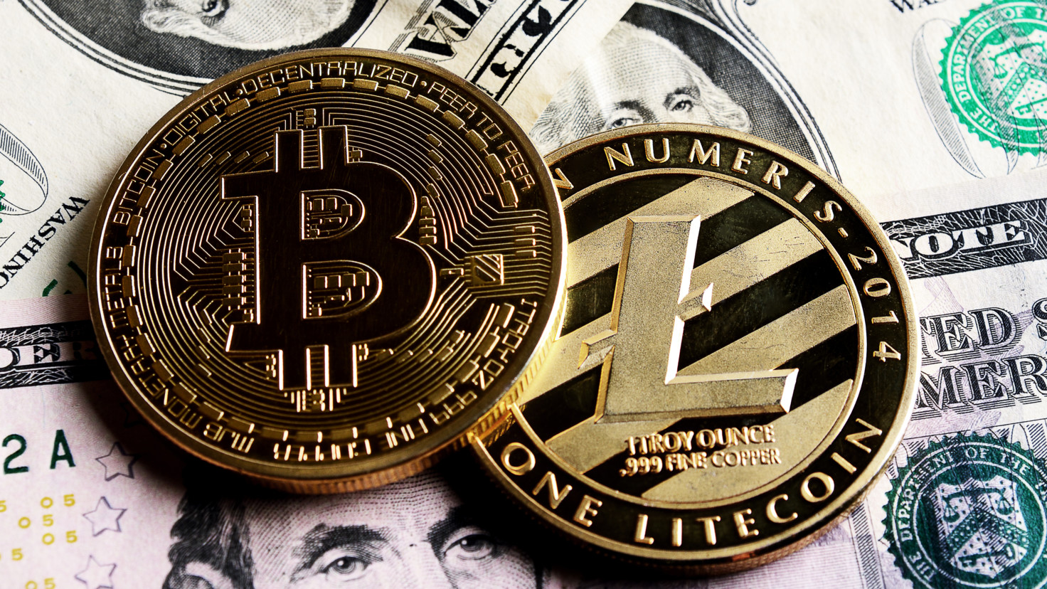 Bitcoin and litecoin tokens on top of US dollar bills